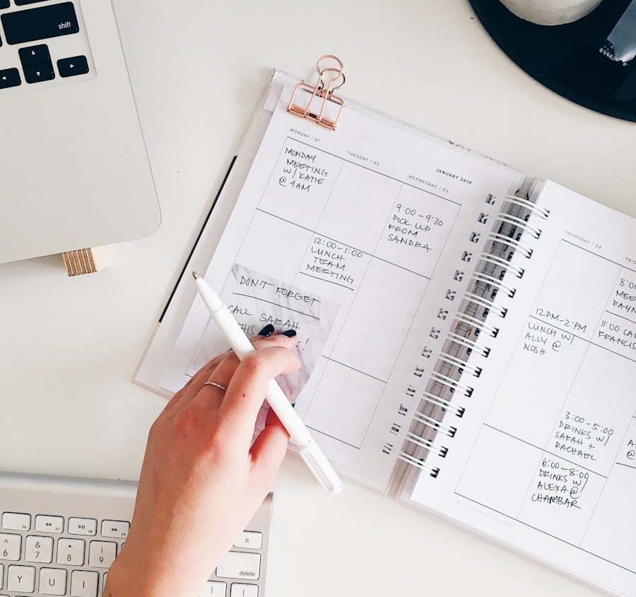 person holding notepad and pen flat lay photography